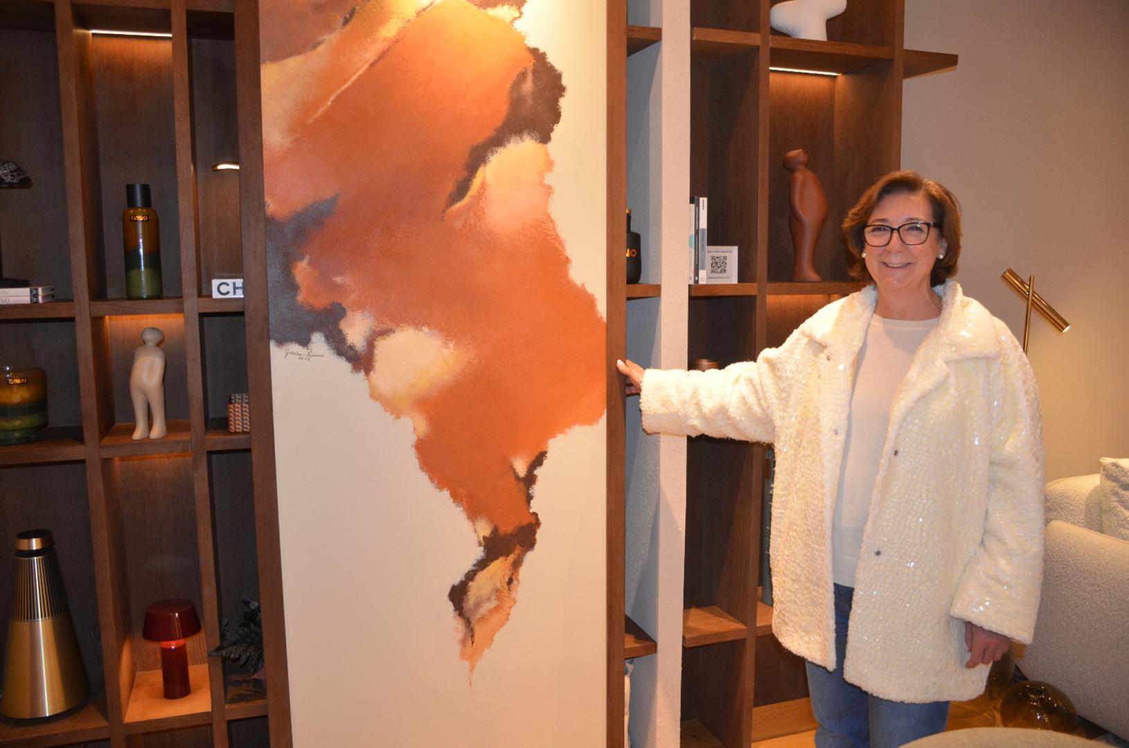 La artista junto a OxidArte, integrada como puerta de una librería en el espacio SERENO, mostrando su escala y relación con la arquitectura.